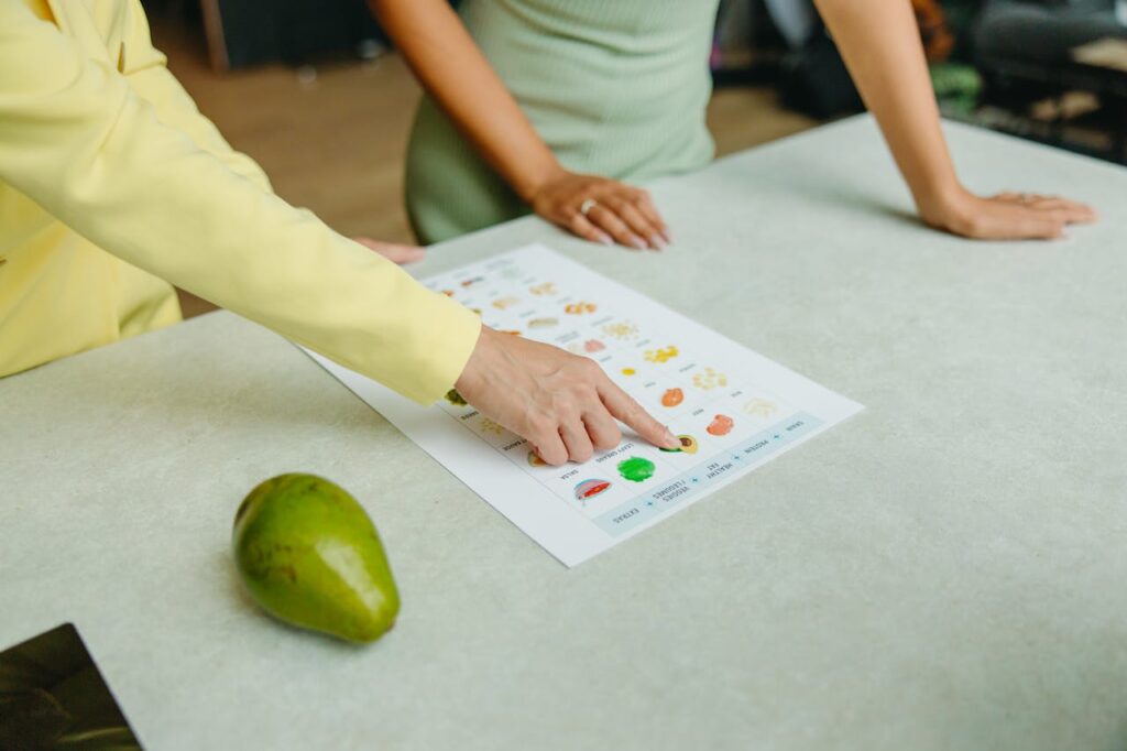 pexels-photo-8844379 Two adults discussing food options with a chart, highlighting healthy nutrition indoors.